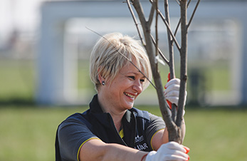 OMV Mitarbeiterin hält kleinen Baum (photo)